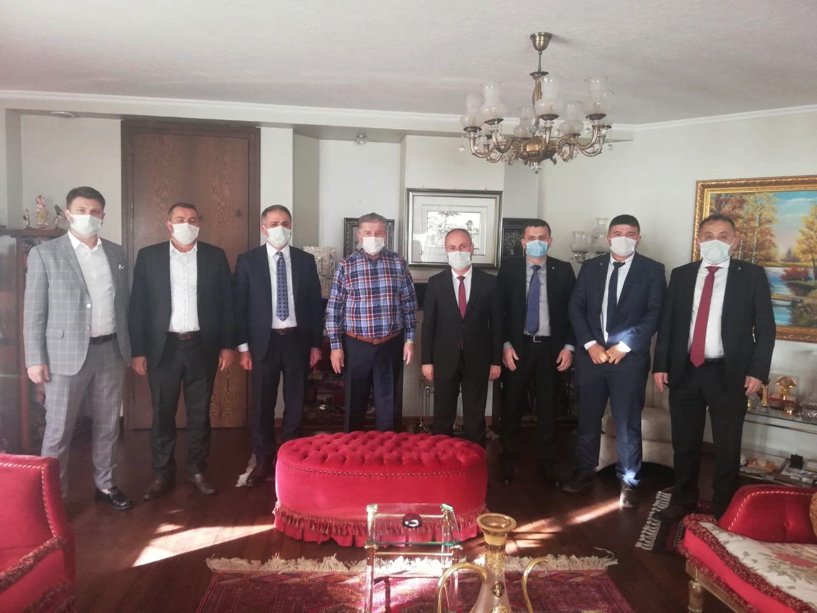 A group photo of eight delegates wearing face masks at a residence