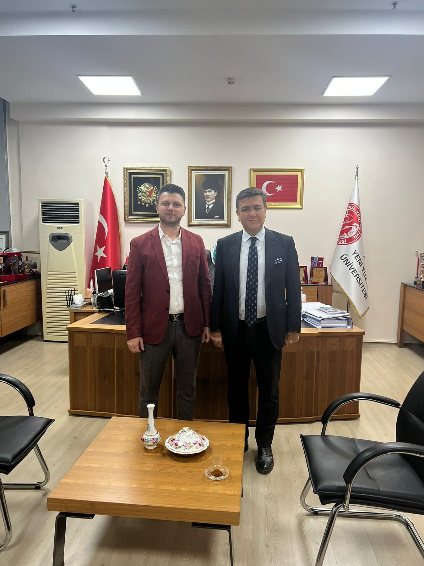 Ömer Yazıcıoğlu with an official in an office at Yeni Yüzyıl University
