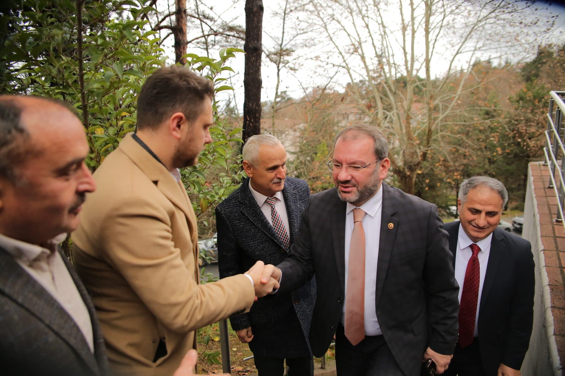 Ömer Yazıcıoğlu shaking hands with a guest he welcomed outdoors