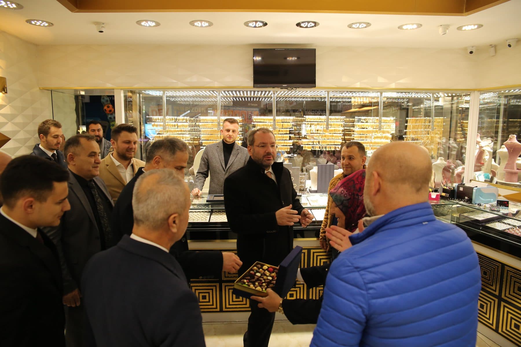 Visitors talking with shopkeepers inside a jewellery store