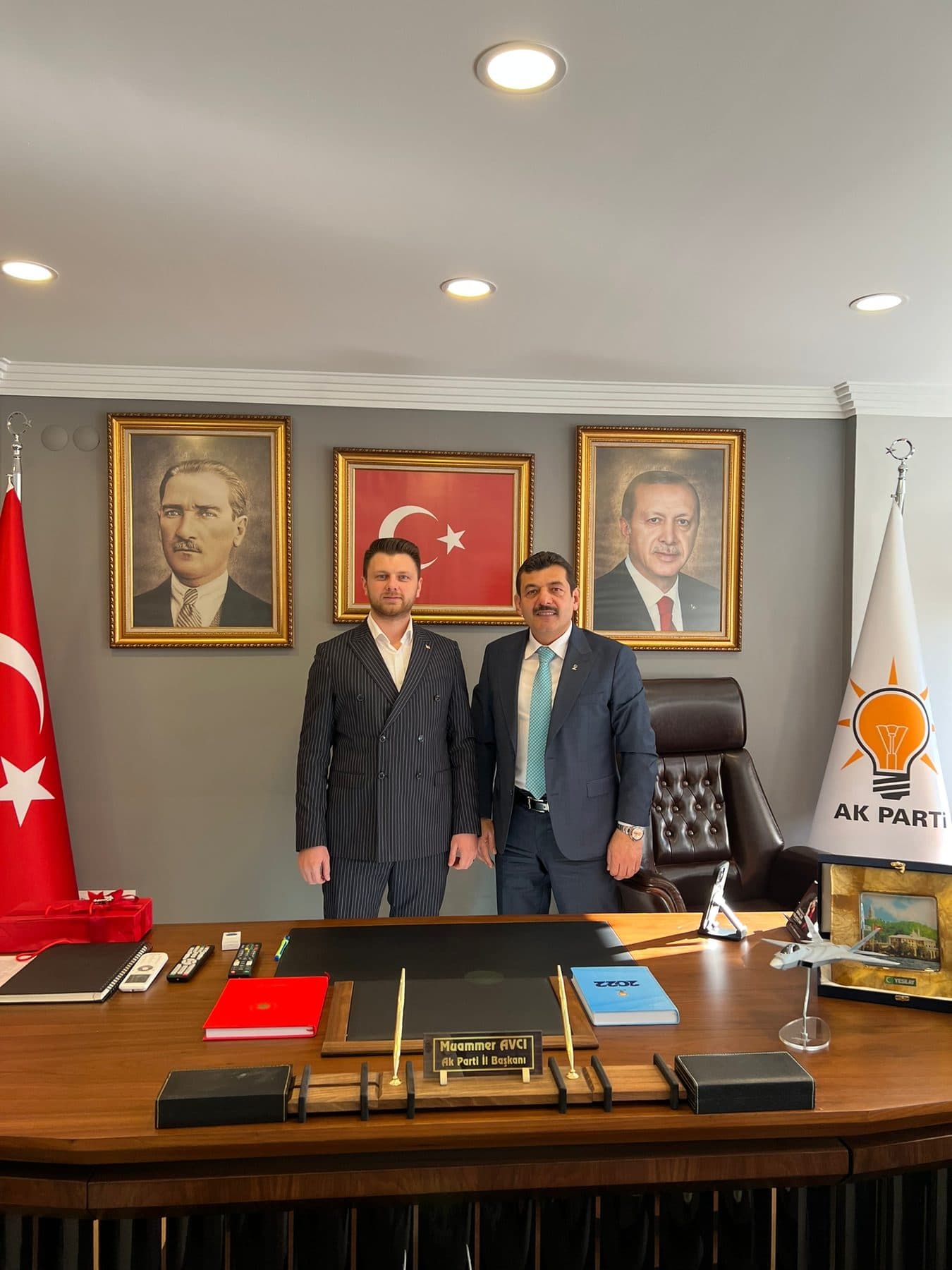 Ömer Yazıcıoğlu with an official in a party office hung with portraits of Atatürk and the President