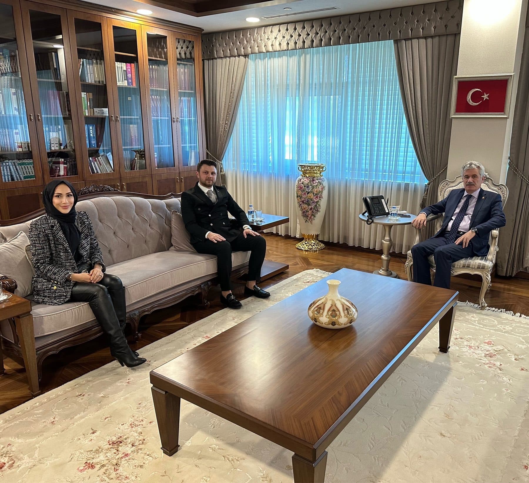 A three-person meeting in the seating area of an official’s office