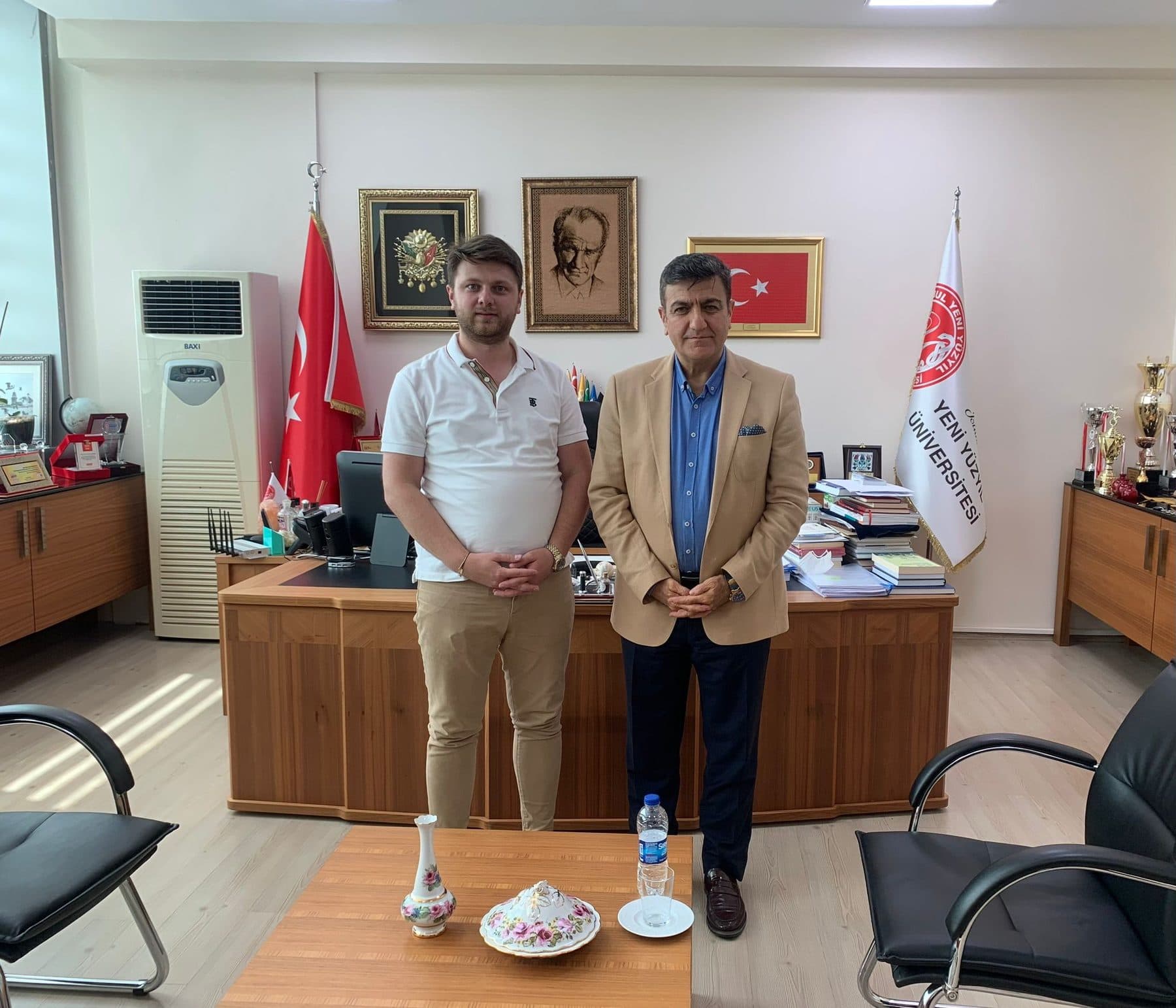 Ömer Yazıcıoğlu with an official at a Yeni Yüzyıl University office